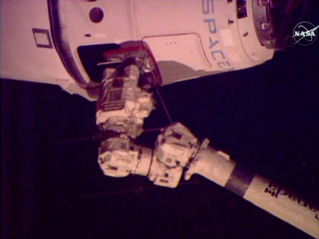 La navicella spaziale Dragon di SpaceX catturata dal braccio robotico della Stazione Spaziale durante la missione CRS-6 (Immagine NASA TV)